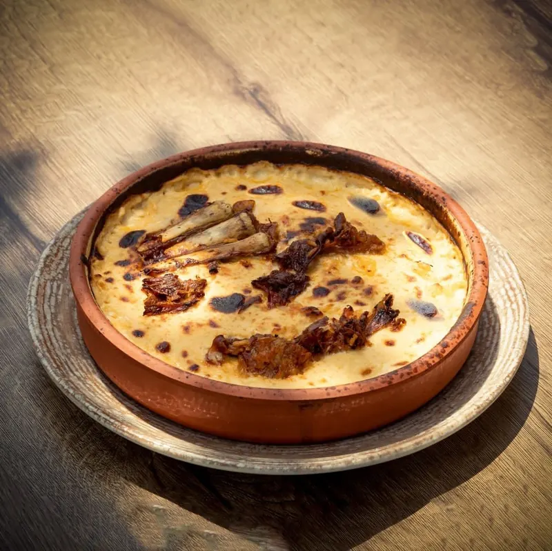 A clay dish baked golden in the oven, served on a wooden table