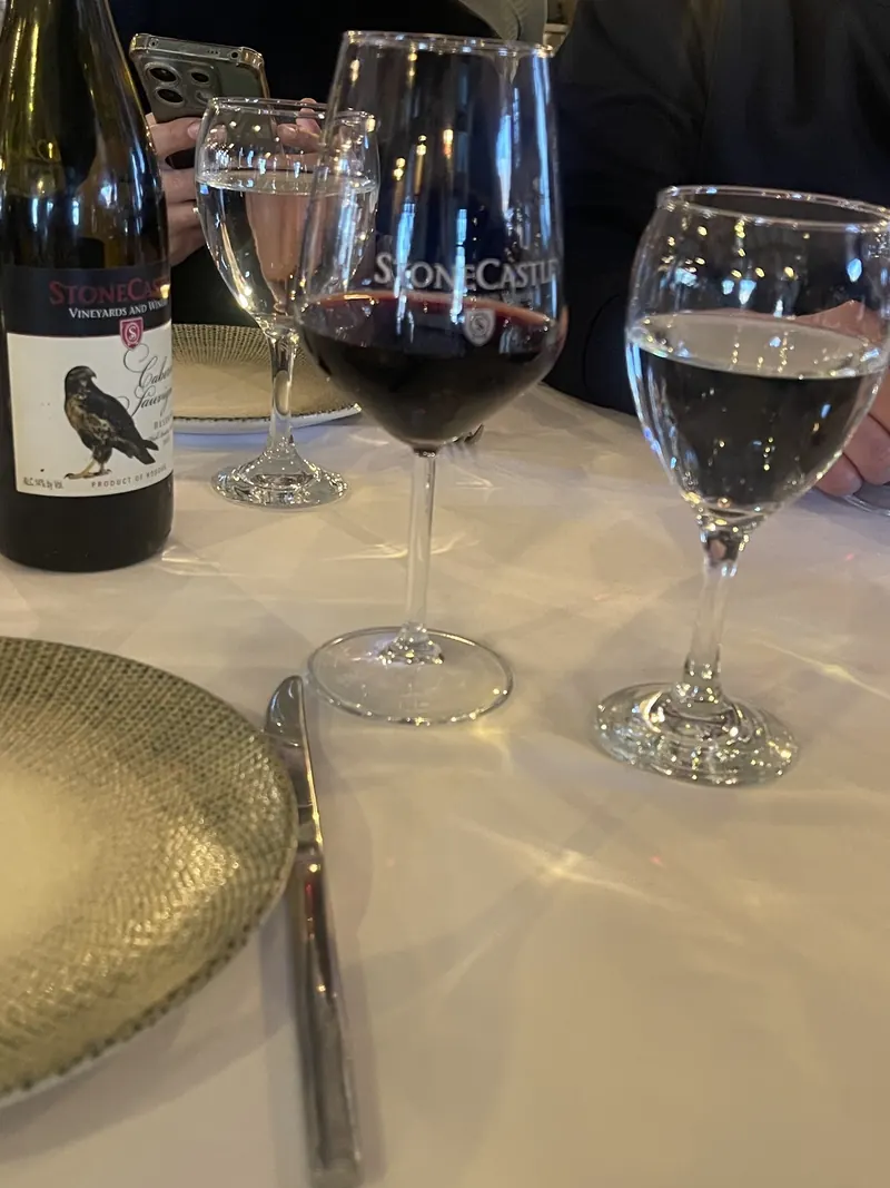 Two glasses of red wine and water on a white tablecloth at night